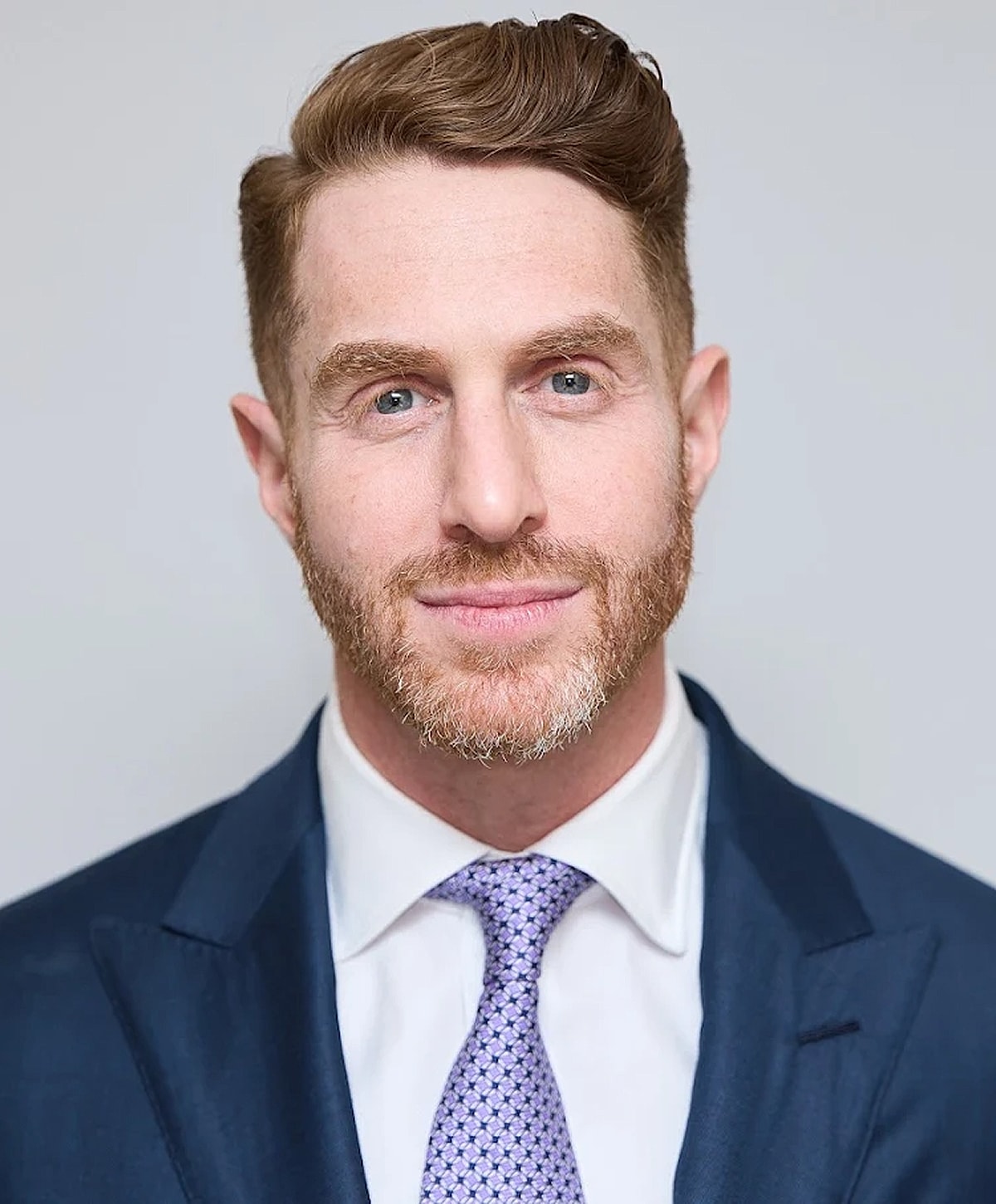 Man in suit with a light purple tie.