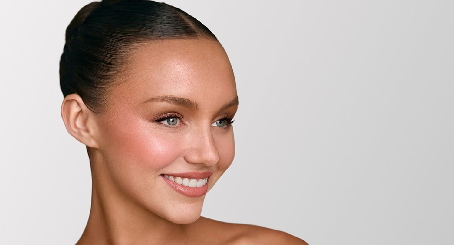 Smiling woman with elegant hairstyle and makeup.