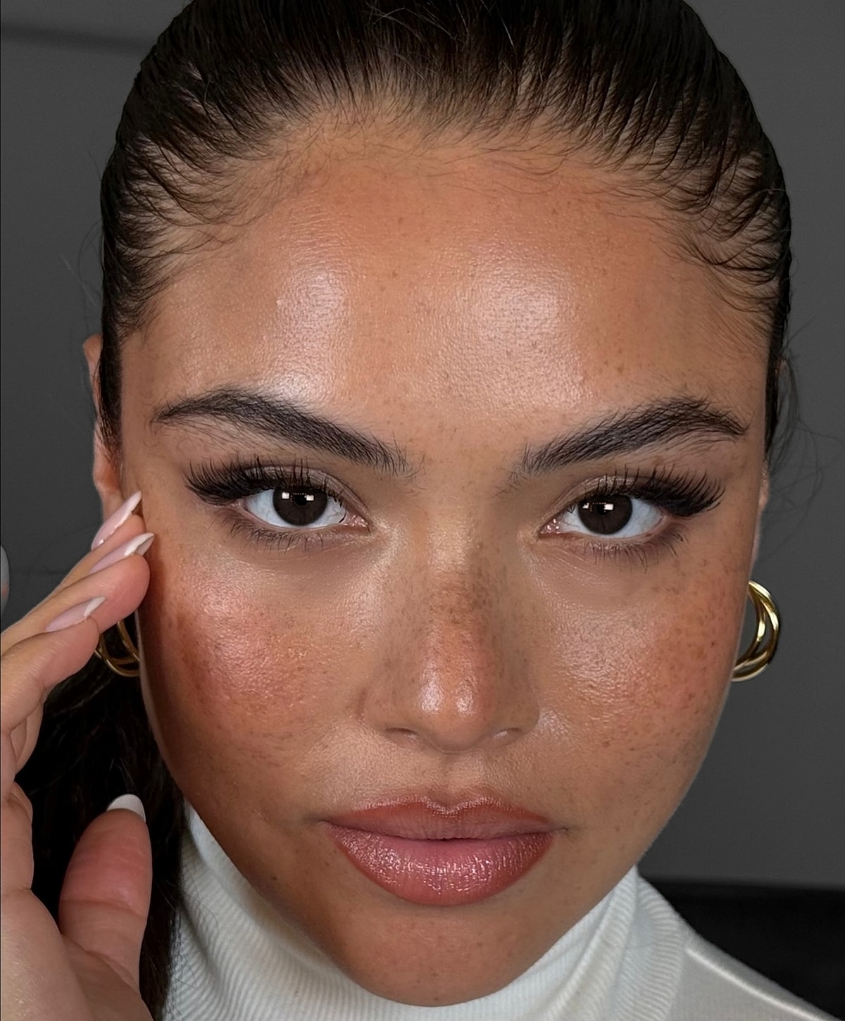Close-up of a confident woman with makeup.