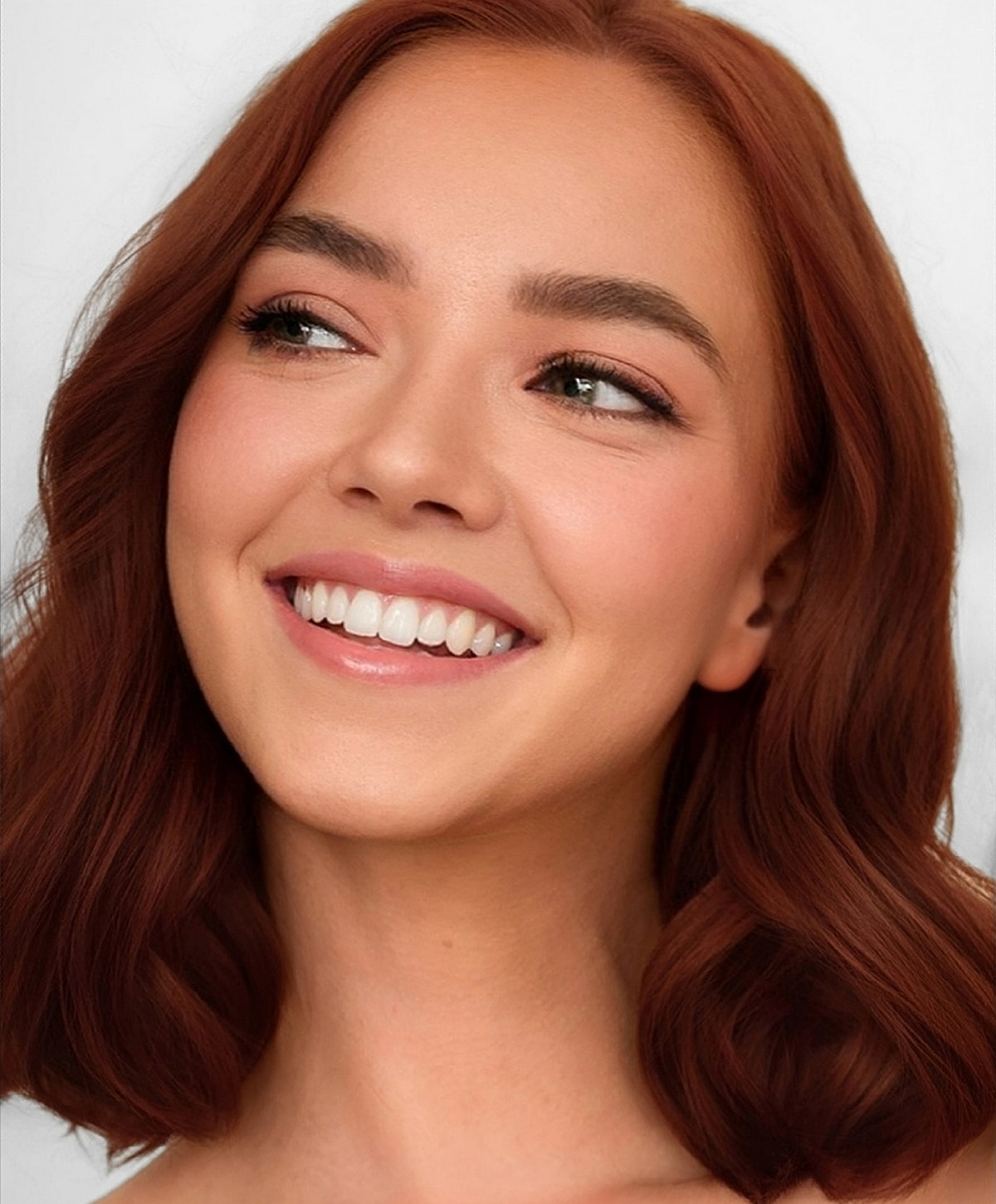 Smiling woman with wavy red hair.