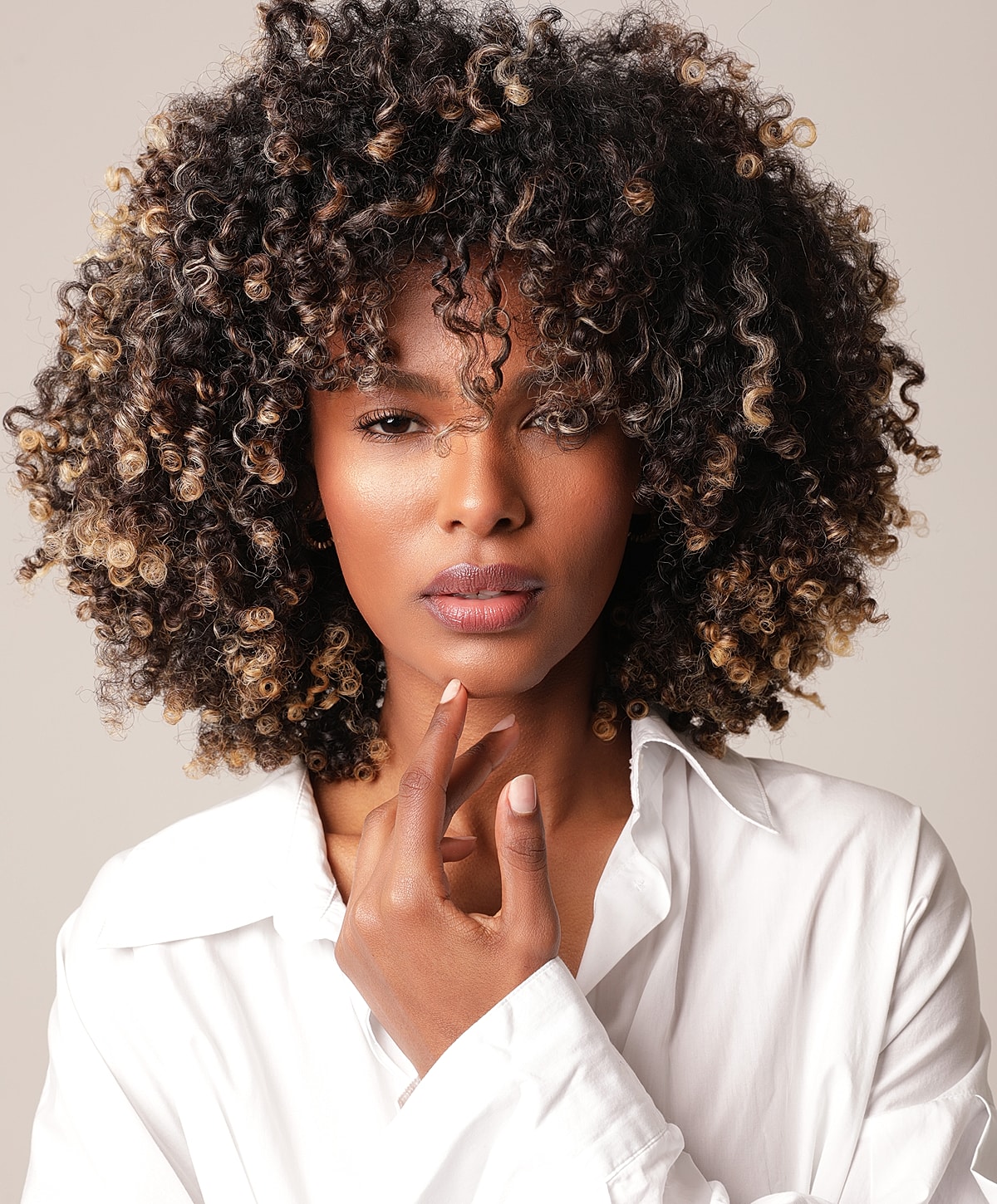 Woman with curly hair in a white shirt.