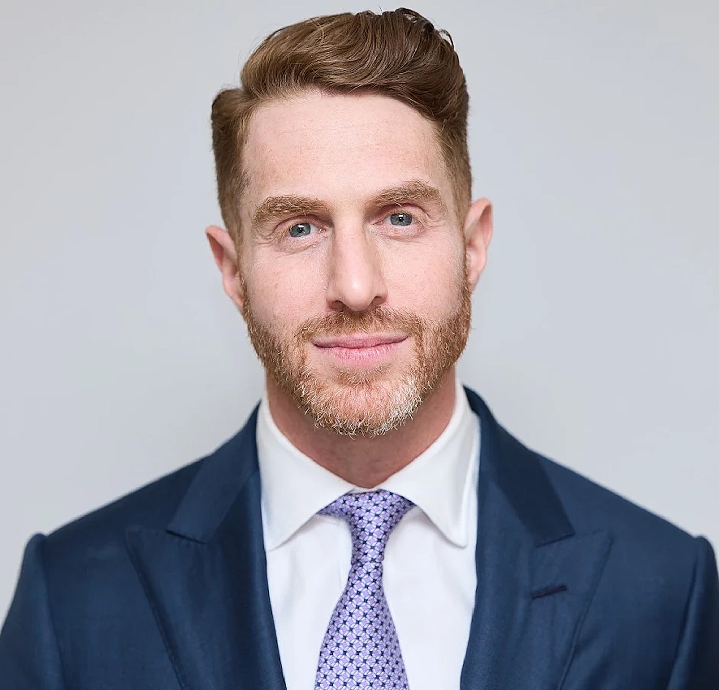 Professional man in suit and tie, smiling.