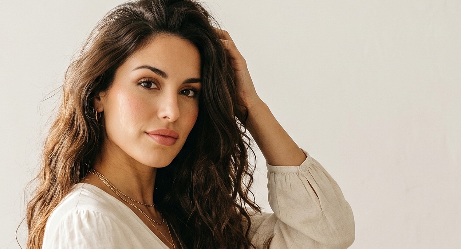 Woman with long, wavy hair posing gently.