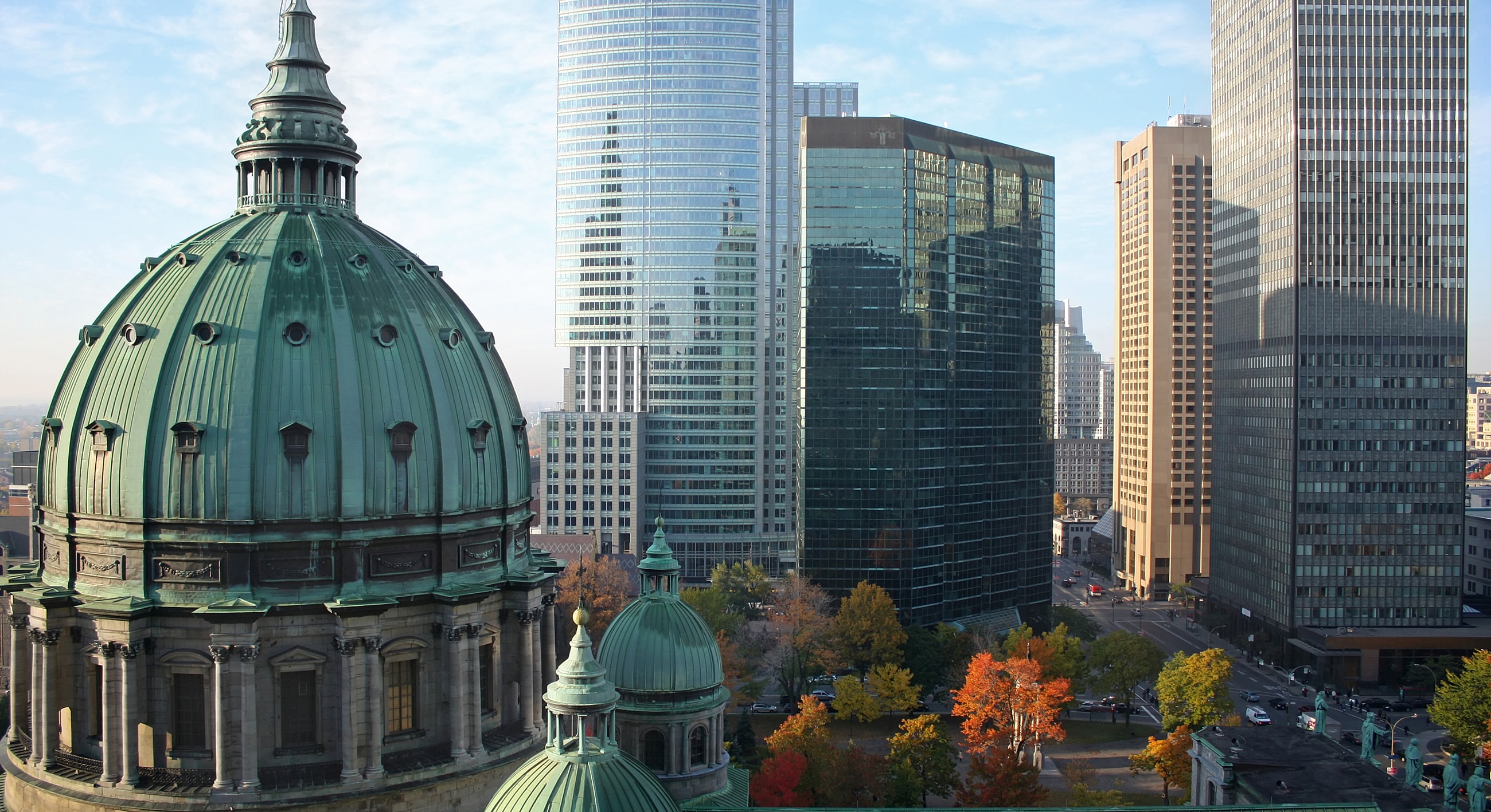Historic dome with modern city skyline backdrop.